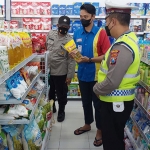 Personel Bhabinkamtibmas Gresik saat mengecek ketersediaan minyak goreng di minimarket Desa Dahanrejo, Kecamatan Kebomas. Foto: SYUHUD/ BANGSAONLINE