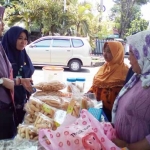 Kabid P2HP Evi Afianasari dan Kasi akses pasar promosi dan logistik bidang P2HP Farida sedang membeli produk bazar. foto: devi/ BANGSAONLINE