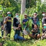 Koordinator ARPL Kediri dr. Ari Purnomo Adi (jongkok paling kiri) dan Plt. Kepala DLH Kabupaten Kediri Putut Agung Subekti (jongkok paling kanan) bersama para relawan usai ikut menanam pohon di kawasan Cagar Alam Alas Simpenan. (foto: MUJI HARJITA/ BANGSAONLINE)