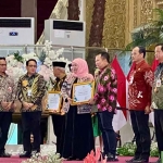 Bupati Jember, Hendy Siswanto, saat menerima penghargaan dari Gubernur Khofifah.