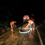 Petugas BPBD Pamekasan bersama UPT Bina Marga Provinsi Jatim dan relawan FRPB saat melakukan pembersihan material longsor.