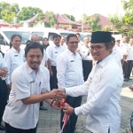 Bupati Bangkalan memberikan kunci kepada salah satu kepala Puskesmas penerima bantuan mobil ambulans.