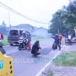 Perbaikan di salah satu ruas jalan yang rusak.