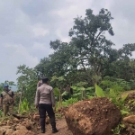 Kamid selaku Kepala Dusun Kajar, Desa Kalipang, Kecamatan Grogol, Kabupaten Kediri, bersama aparat kepolisian saat mengecek lokasi longsor. Foto: Ist