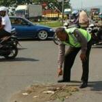 Petugas dari Unit Laka Lantas Polsek Porong menunjukkan lokasi tabrakan karena menerobos TL. foto: nanang ichwan/ BANGSAONLINE