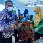 Direktur Perumda Pasar Lamongan, Suhartono saat menyapa salah seorang pedagang yang sedang divaksin.