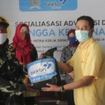 Anggota Komisi IX DPR RI melalui Staf Ahli Noor Fuadi saat memberikan sembako secara simbolis pada kegiatan sosialisasi BKKBN.