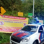 Petugas dari Satlantas Polres Batu saat memasang imbauan di Jembatan Cangar.