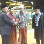 Ketua PWNU Jatim KH. Marzuki Mustamar mendapat cinderamata saat menghadiri wisuda STAI Daruttaqwa.