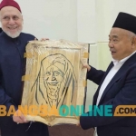 Prof Dr KH Asep Saifuddin Chalim, MA, memberikan cenderamata lukisan kepada Prof Dr Syaikh Muhammad Abdus Shomad Muhanna, penasehat Iman Besar Al Azhar dan ahli hukum internasional yang sangat populer dan berpengaruh di Mesir.  Kiai Asep memberikan cenderamata itu di kediaman Syaikh Muhanna di  Kairo, Mesir, Ahad (8/1/2023) malam. Foto: MMA/ BANGSAONLINE
