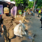 Petugas saat menyita barang dagangan yang ditinggalkan pemiliknya.