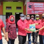 Ketua DPC PDIP Kabupaten Kediri Murdi Hantoro (topi hitam) saat menyerahkan secara simbolis bantuan beras kepada Ketua PAC PDIP Kecamatan Gampengrejo Imam Muklas, didampingi jajaran pengurus lainnya. foto: MUJI HARJITA/ BANGSAONLINE