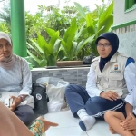 Petugas dari Satgas Polresta Malang Kota bagian Trauma Healing saat memberi bantuan psikologis kepada seorang bocah laki-laki berinisal P (7 tahun) dari Kelurahan Tlogowaru, Kecamatan Kedungkandang.