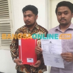 Suami korban pelecehan saat menunjukkan bukti laporan di Polda Jatim. Foto: RUSMIYANTO/BANGSAONLINE