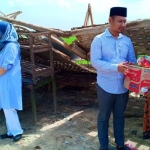 Kang Yudi ditemani istri menyerahkan sejumlah paket sembako kepada para korban angin puting beliung.