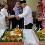 Dr Ami Primarni saat menerima potongan tumpeng dari Prof Dr KH Asep Saifuddin Chalim, MA, dalam acara tasyakuran di Kantor Bapengda Pemprov Jatim Jalan Pasuruan 16-20 Jakarta Pusat, Jumat (10/11/2013). Tampak juga Nyai Hj Alif Fadhilah, istri Kiai Asep, juga menyaksikan. Foto: M Mas