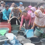 Kapolres saat ikut bantu membagikan air bersih.