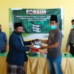 Moh. Ali Achmad (kiri), Penasihat Forsim memberikan kacamata sefety secara simbolis kepada Ketua Relawan Kwanyar Syafii di Puskesmas Kwanyar, Selasa (11/4/2020).