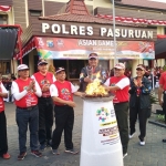 Kapolres Pasuruan saat menyalakan Api Obor pembuka Asian Games Mini di halaman Mapolres Pasuruan. Foto: ANDY F/BANGSAONLINE