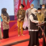 Gubernur Jawa Timur, Khofifah Indar Parawansa bersama Kiai Asep, saat mengundi pemenang hadiah tabungan umroh bagi wajib pajak kendaraan bermotor patuh periode II tahun 2021. foto: ROCHMAT SAIFUL ARIS/ BANGSAONLINE