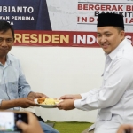 Ketua DPC Partai Gerindra, H. M. Rusdi Sutejo (kanan) saat menyerahkan potongan tumpeng.