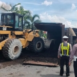 Alat berat harus didatangkan untuk membersihkan tumpahan batu bara di jalanan.