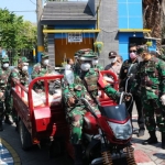 BAHU MEMBAHU: Personel Kodim 0816/Sidoarjo saat membagikan beras kepada warga di Desa Pabean, Sedati, Selasa (14/4). foto: MUSTAIN/ BANGSAONLINE