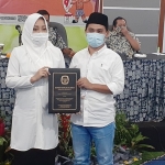 Pasangan dr. Ikhfina Fatmawati, M.Si. dan H. Muhammad Al Barra, Lc. M.Hum. sedang menunjukkan SK penetapan mereka sebagai pasangan calon bupati dan wakil bupati terpilih, hasil Pilkada Serentak 2020.