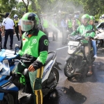 Penyemprotan disinfektan kepada pengendara ojek online (Ojol) di depan Gedung Negara Grahadi Surabaya, Minggu (22/3) siang.