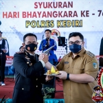 Bupati Kediri Hanindhito Himawan Pramana (kanan) saat menyerahkan potongan tumpeng kepada Kapolres Kediri AKBP Agung Setyo Nugroho. Foto: Ist.