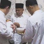 Dr. KH. Asep Saifuddin Chalim, MA saat memotong rambut Abdul Hakim, cucunya yang ke-10, dalam acara istighotsah aqiqah.  Tampak Abdul Hakim, digendong oleh sang ayah Muhammad Habibur Rohman (Gus Habib).