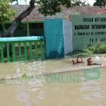 Siswa MI Nizamiyah tampak asik bermain air di sekolahnya. foto: AAN AMRULLOH/ BANGSAONLINE