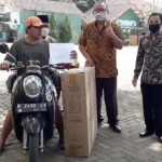 Salah seorang warga Desa Pesanggrahan saat menerima bantuan dari Dinsos Kota Batu.