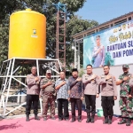 Kapolres Gresik, AKBP Adhitya Panji Anom saat penyerahan bantuan sumur bor. Foto: SYUHUD/BANGSAONLINE.com