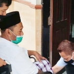 Suherman duduk di kursi roda tampak dibantu saat akan masuk ke ruang sidang. foto: ist.