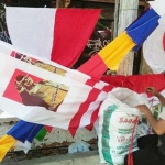 Penjual bendera dan pernak-pernik HUT RI tengah menata barang dagangannya.