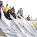 TEBAR: Bupati Gus Muhdlor dan Kapolresta Sidoarjo menebar ribuan ikan nila, di Long Storage Kalimati, Minggu (26/9/2021). foto: Kominfo Sidoarjo