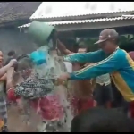 Mukadar saat dimandikan kembang dan ditaburi tepung oleh para tetangganya saat pulang dari karantina.