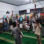 Puluhan jamaah Musalla Baitul Muslim, baik dewasa maupun anak-anak, langsung berdiri untuk berebut pernak-pernik usai doa bersama dalam rangka peringatan Maulid Nabi Muhammad. 