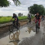 Bupati Gus Yani, bersama Kades Gredek Duduksampean Ghofar saat gowes sambil melihat JPD rusak. foto: SYUHUD/ BANGSAONLINE