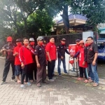 Ketua DPC PDIP Gresik Mujid Riduan (tengah) bersama kader saat memberikan bantuan tempat cuci tangan. foto: ist