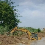 Alat berat berupa ekskavator yang terendam saat pengerjaan proyek di Kali Lamong. Foto: Ist