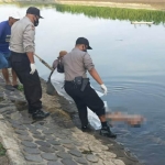 Petugas saat mengevakuasi jenazah di aliran anak Sungai Brantas. foto: AAN AMRULLOH/ BANGSAONLINE