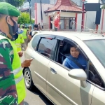 Petugas menghentikan pengendara mobil yang kedapatan tak memakai masker.