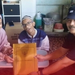 Penyerahan bantuan biaya pendidikan oleh Kepala Dinas P3A Choirul Anwar di rumah Muhammad Fajar Mulyo. 