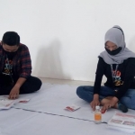 Petugas pelipatan surat suara saat melakukan tugasnya.