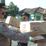 Kapolres Probolinggo AKBP Teuku Arsya Khadafi saat menyerahkan bantuan di area Makodim 0820/Probolinggo. (foto: ist)