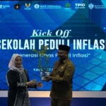 Deputi Kepala Perwakilan Wilayah Bank Indonesia Kediri, Wihujeng Ayu Rengganis, saat menyerahkan pohon kepada Kepala Dinas Pendidikan Kota Kediri, Anang Kurniawan. Foto: Ist