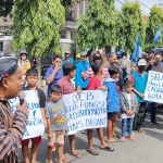 Supriyo, Korlap Aksi, saat berorasi didepan masa aksi yang melibatkan anak-anak. Foto: Muji Harjita/BANGSAONLINE.com