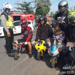 Petugas sedang menghentikan 4 pengendara motor mini.